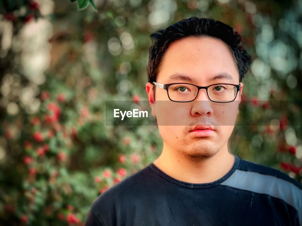 PORTRAIT OF A YOUNG MAN WEARING EYEGLASSES