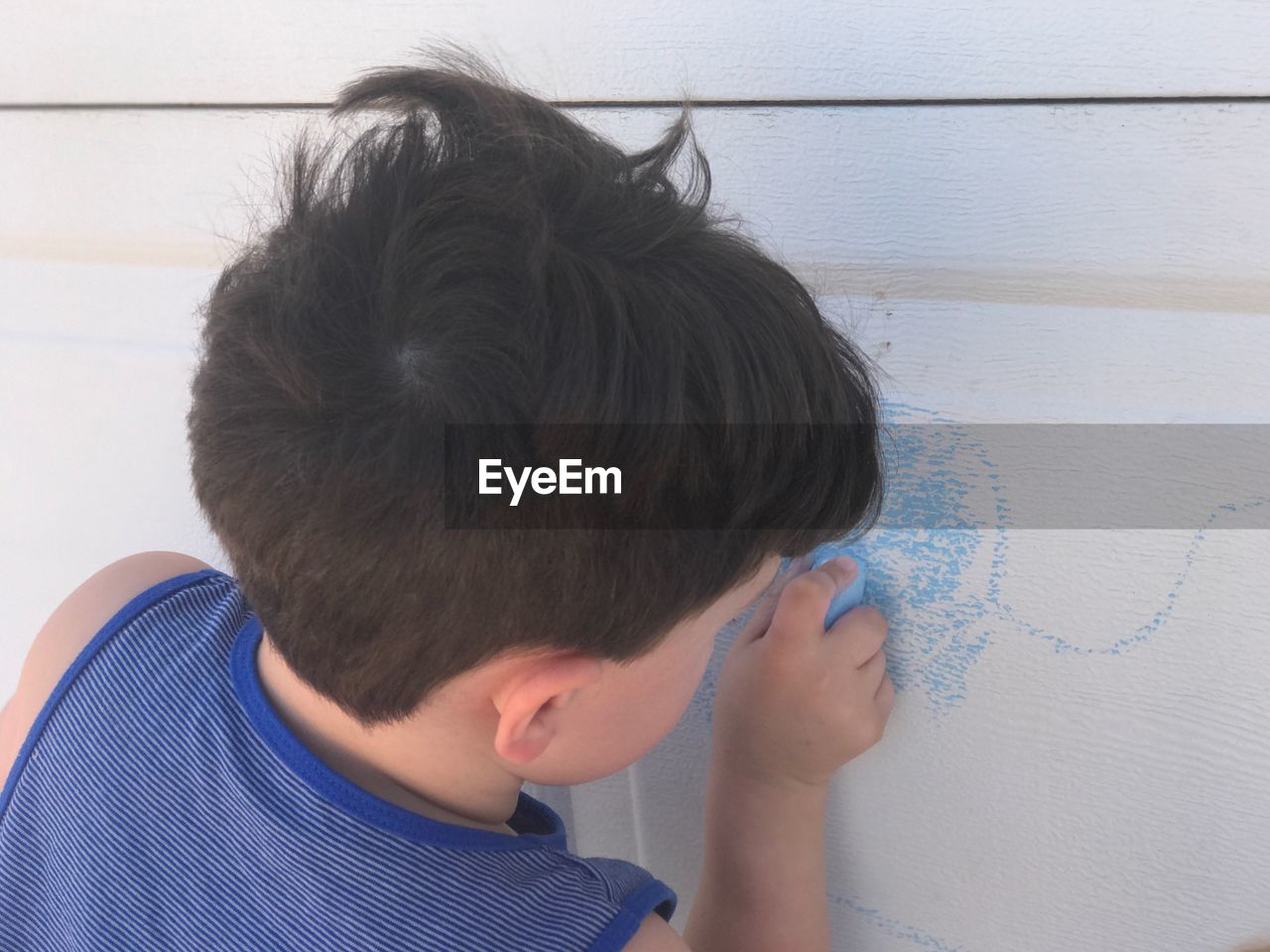 Close-up of boy drawing on wall