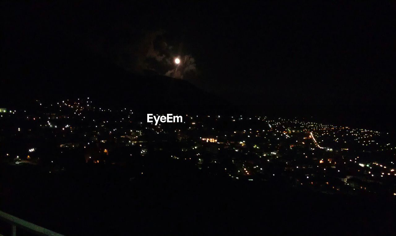 VIEW OF ILLUMINATED CITYSCAPE AT NIGHT