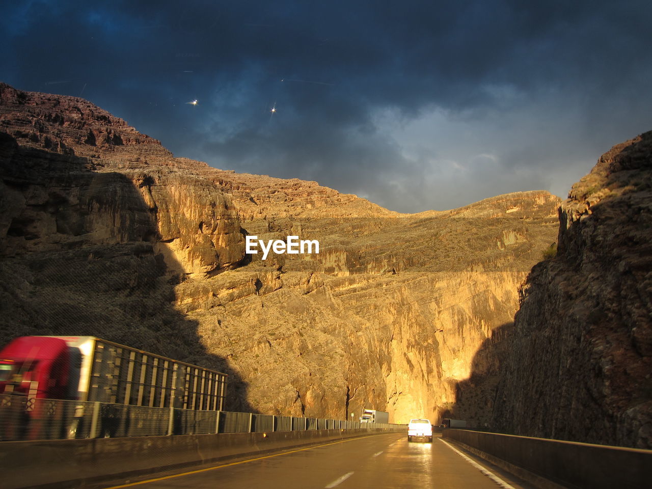 ROAD AMIDST DRAMATIC SKY OVER MOUNTAIN