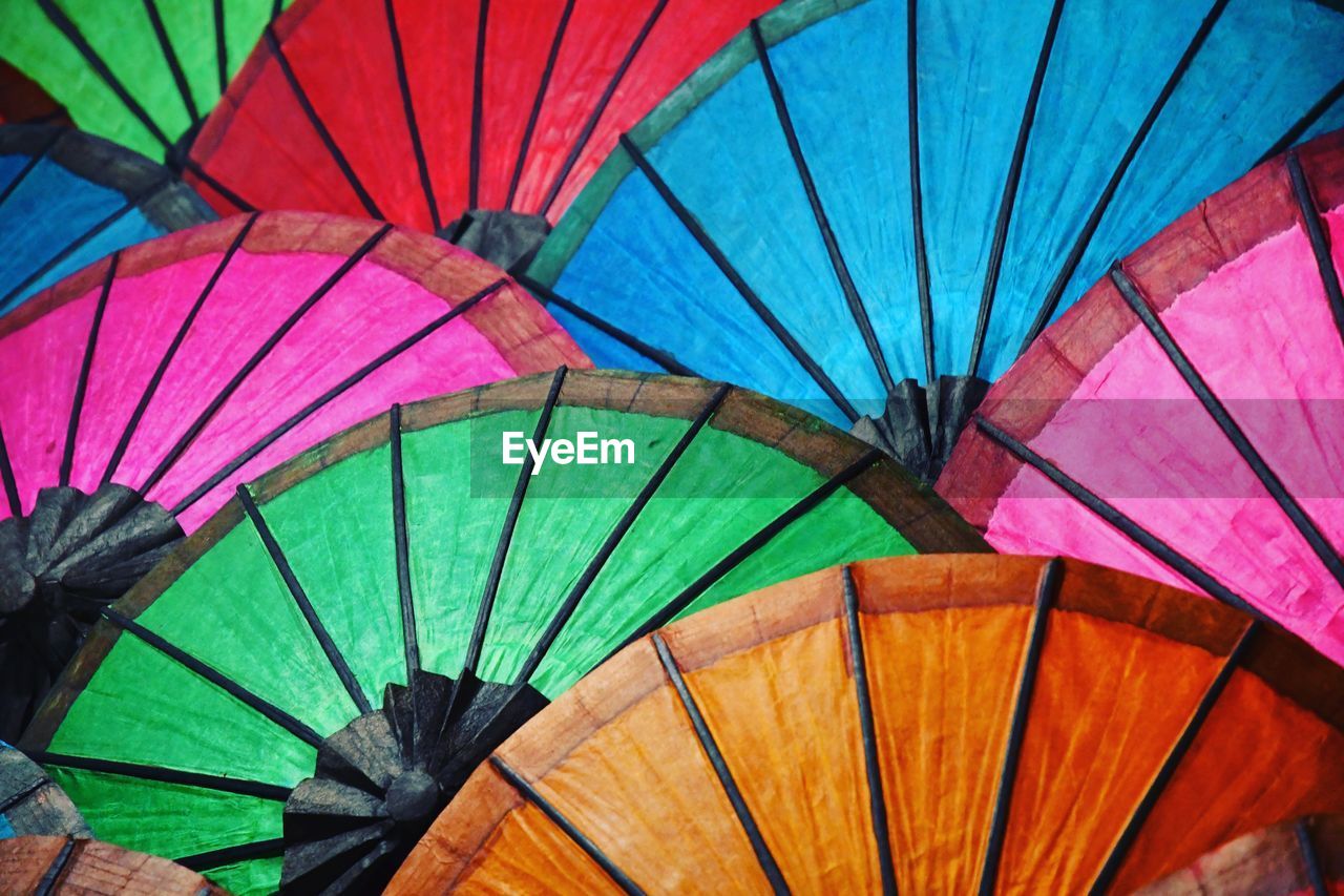 LOW ANGLE VIEW OF MULTI COLORED UMBRELLAS AT MARKET