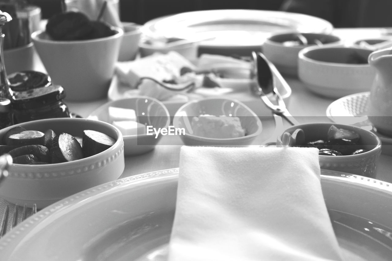 black and white, meal, food and drink, monochrome photography, plate, coffee cup, table, indoors, monochrome, no people, food, white, tableware, cup, household equipment, kitchen utensil, still life, crockery, eating utensil, close-up, restaurant, mug, business, black