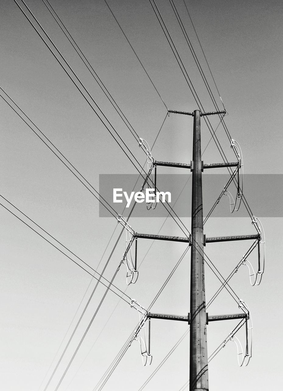 Low angle view of electricity pylon against clear sky