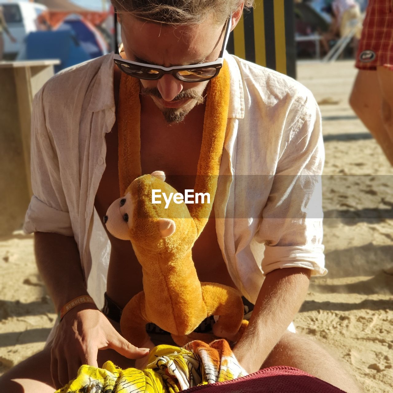 FULL LENGTH OF MAN HOLDING TOY WHILE SITTING BY TOYS