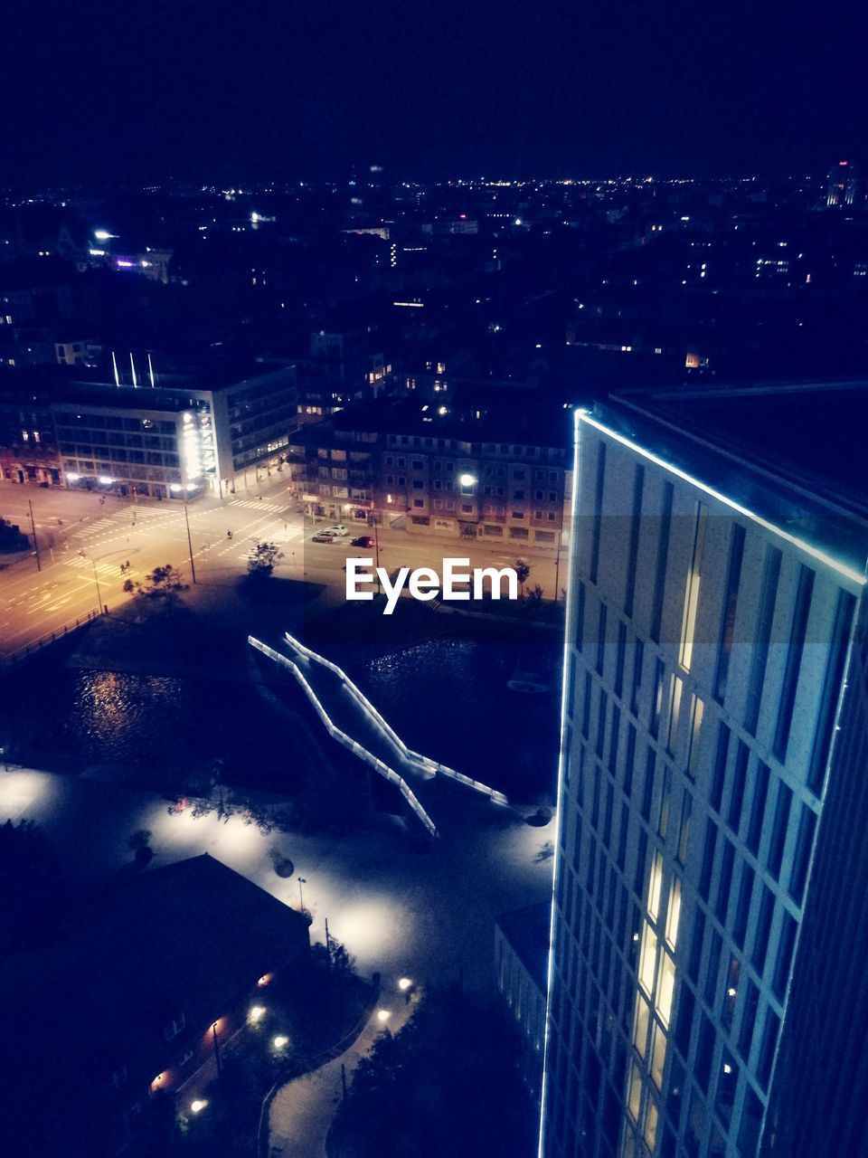 HIGH ANGLE VIEW OF ILLUMINATED STREET AND BUILDINGS AT NIGHT