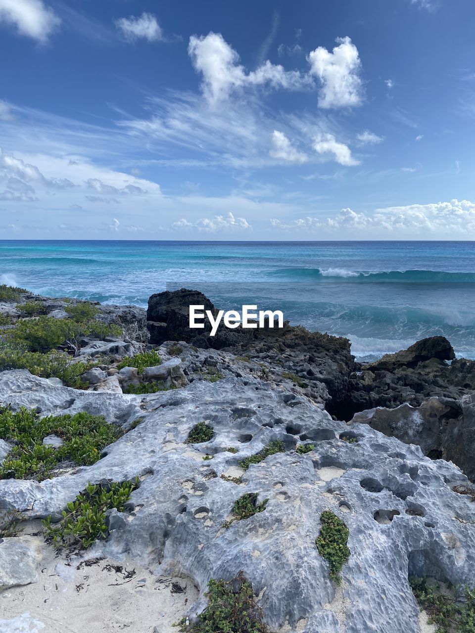 ROCKS ON BEACH AGAINST SKY