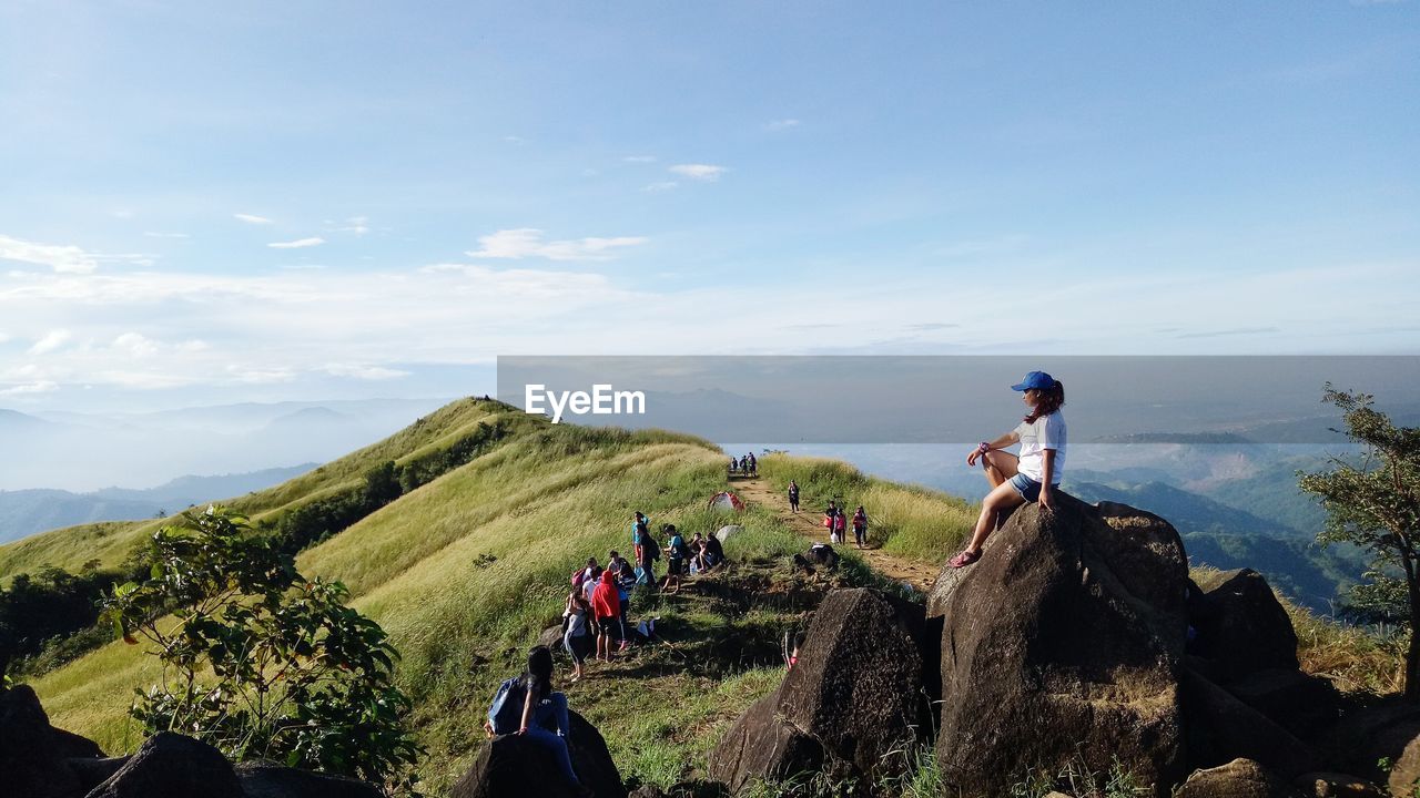 PANORAMIC VIEW OF PEOPLE ON MOUNTAIN AGAINST SKY