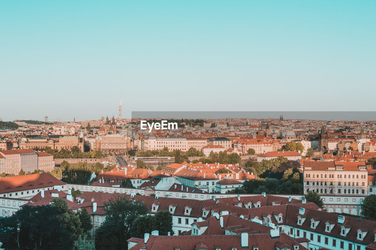 Aerial view of buildings in city against clear sky