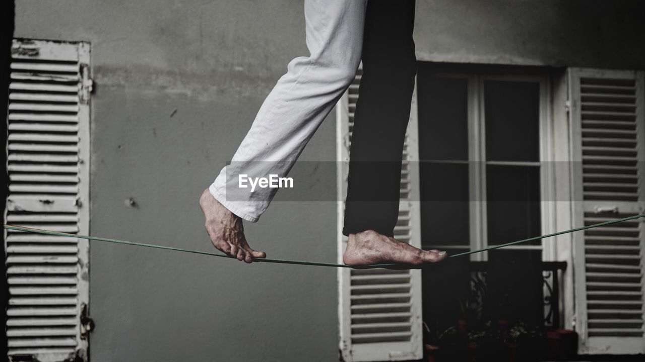 LOW SECTION OF MAN STANDING ON GLASS