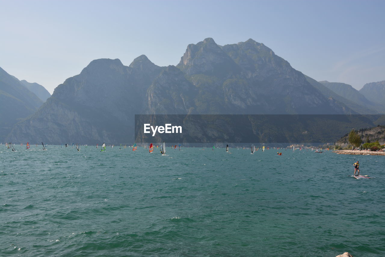 PEOPLE IN SEA AGAINST MOUNTAINS