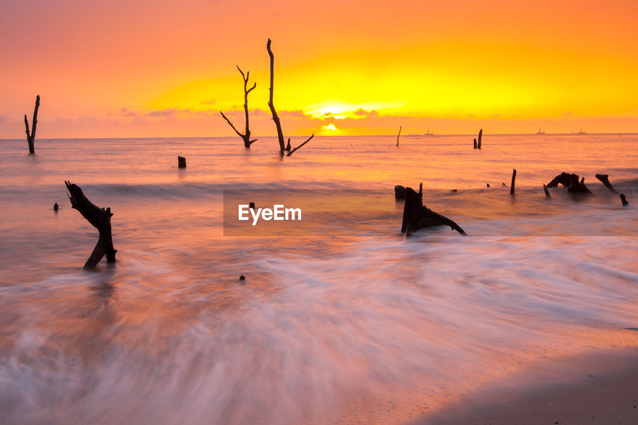 Beach against orange sky