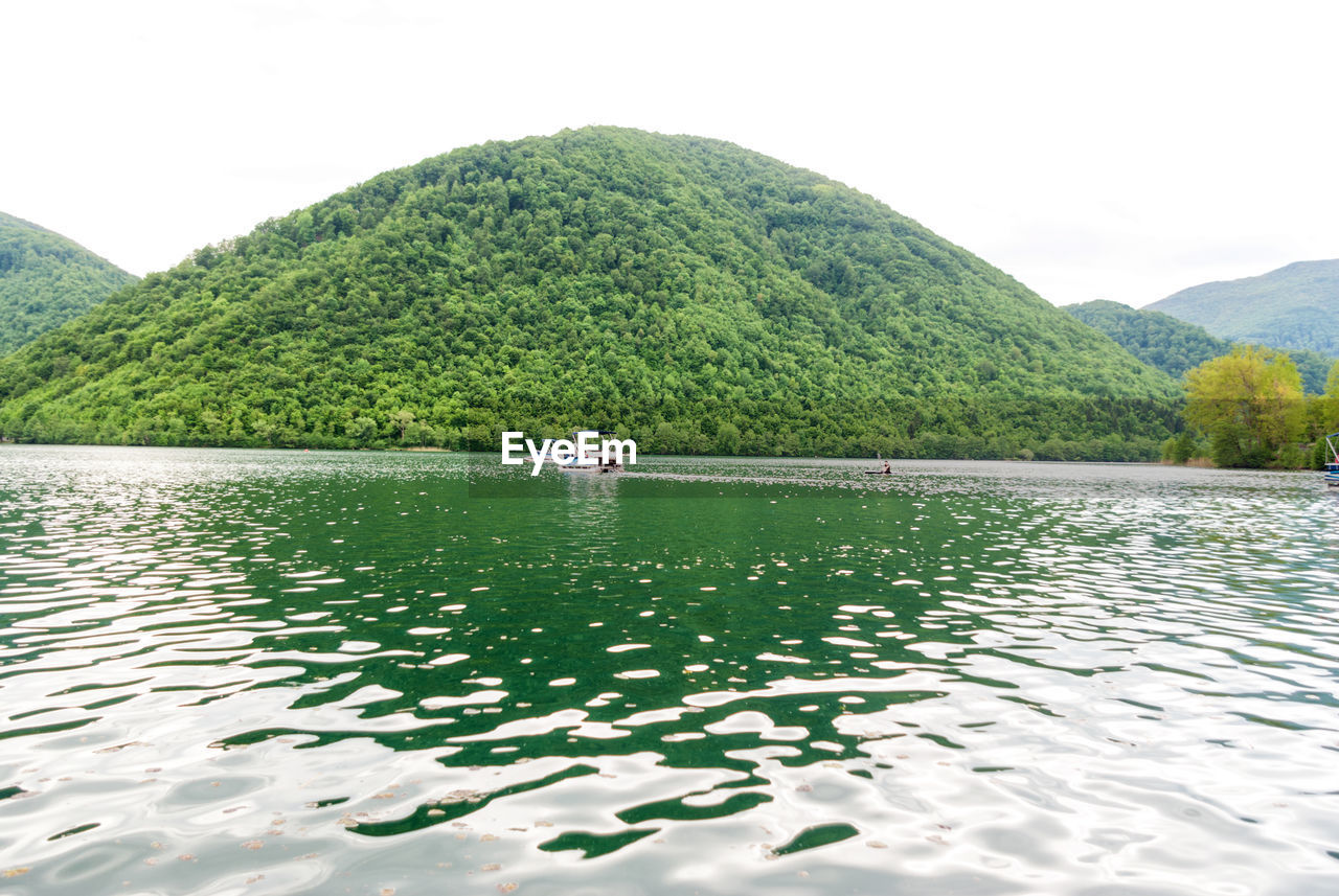 Scenic view of lake by mountain against sky