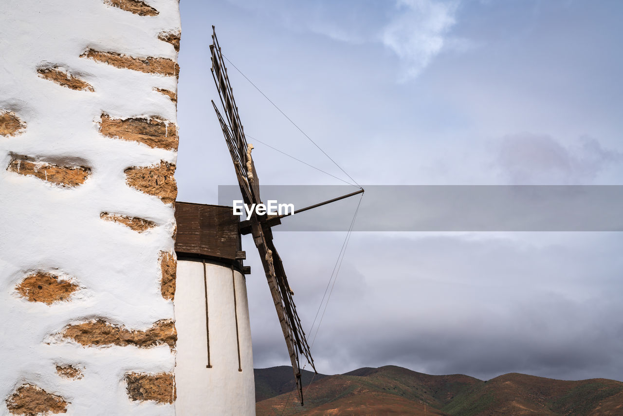 WIND TURBINES ON SNOW FIELD AGAINST SKY