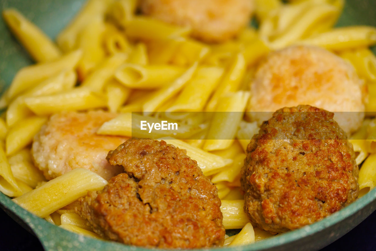 Pasta with meatballs in skillet, close-up