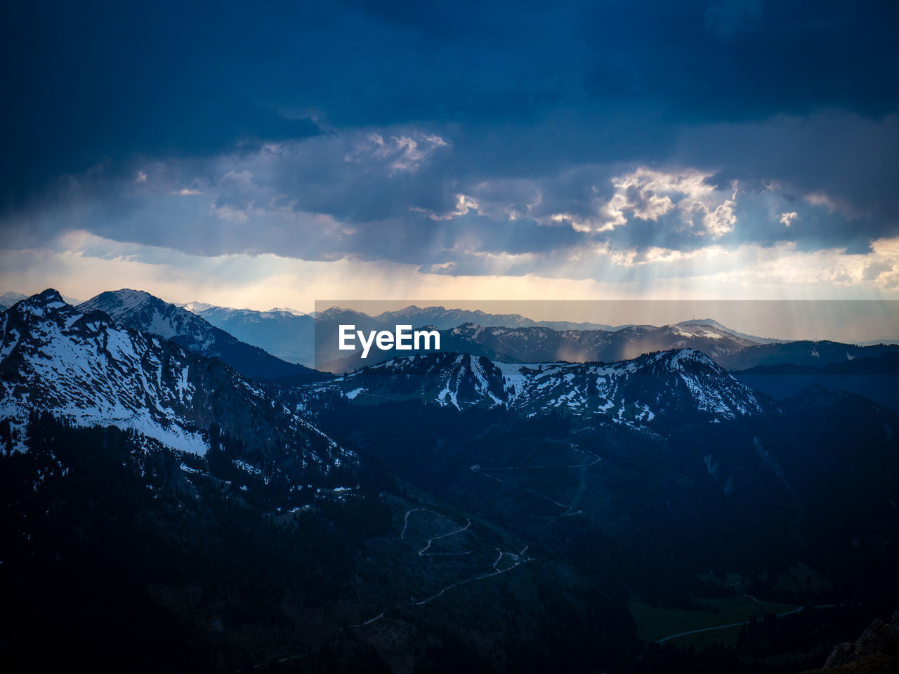 Scenic view of snowcapped mountains against dramatic sky