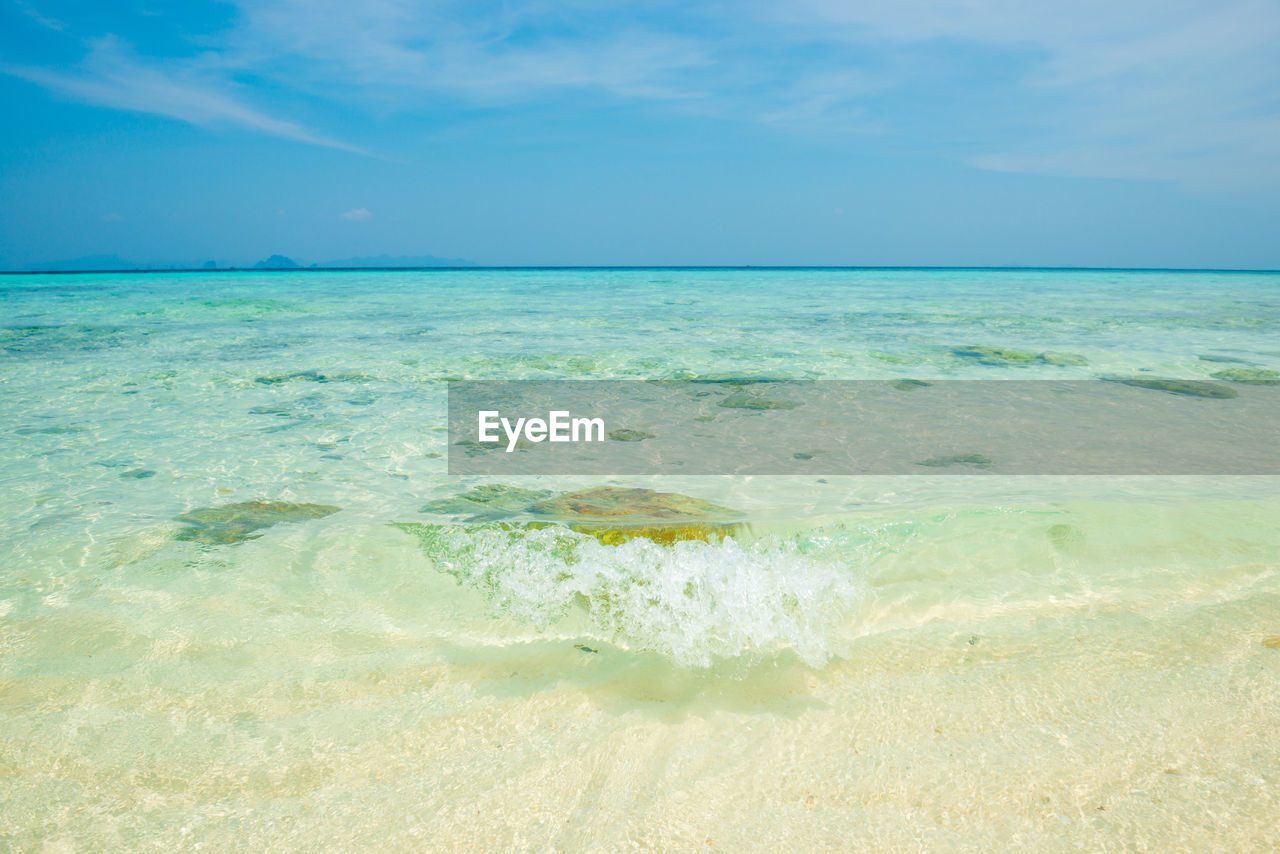 Seascape of tropical sea with clear transparent turquois water, corals, stones and blue sky
