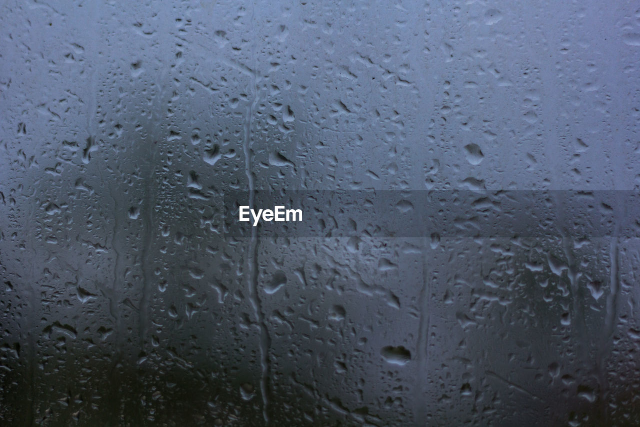 Full frame shot of raindrops on glass window