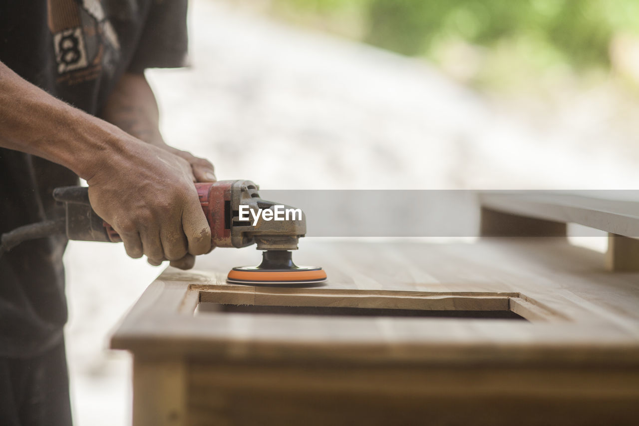 midsection of man working on table