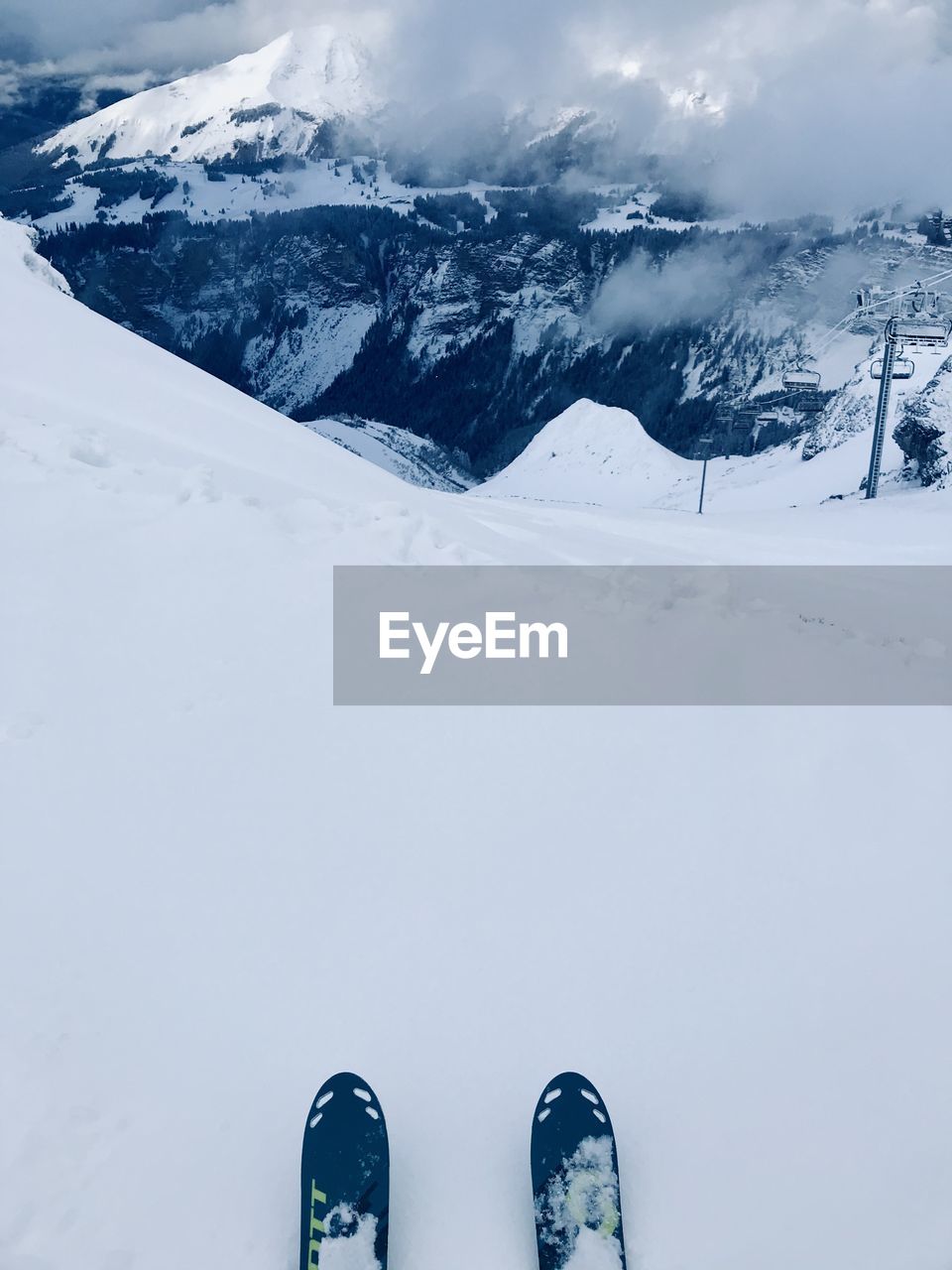 Low section of skis on snowcapped mountain