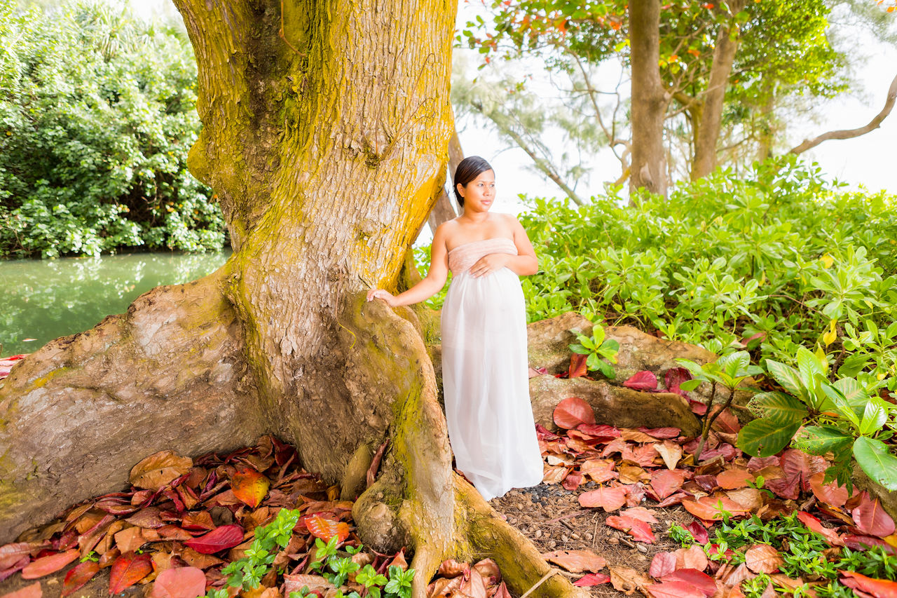 Woman standing near tree in forest