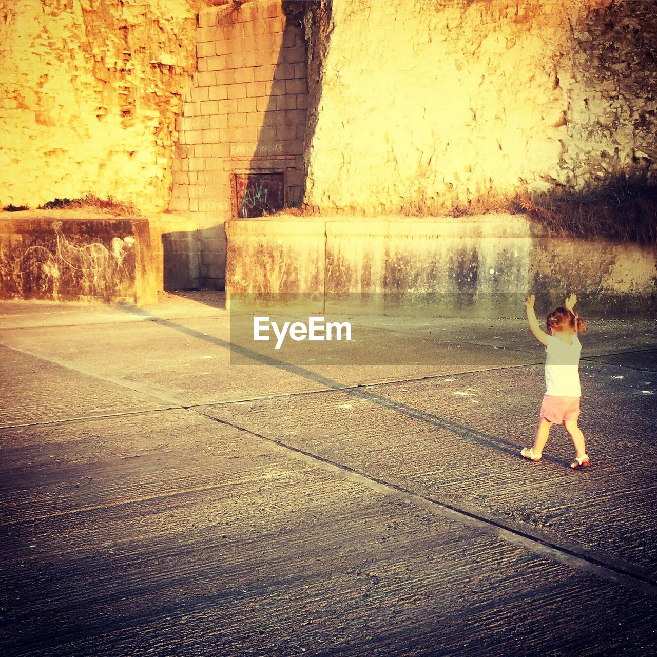 LOW SECTION OF WOMAN STANDING ON COBBLESTONE