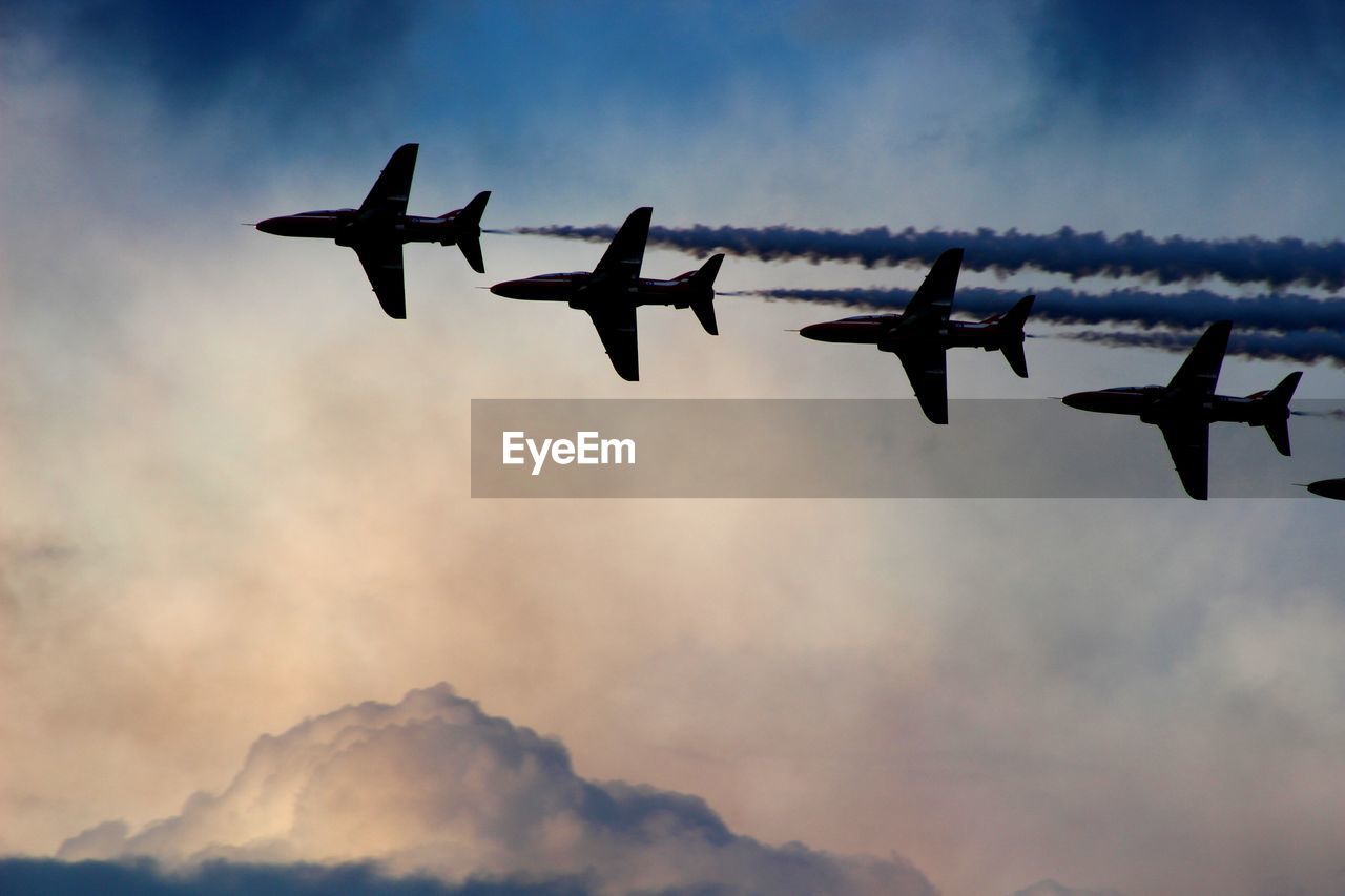 Low angle view of bae hawk jets flying against sky