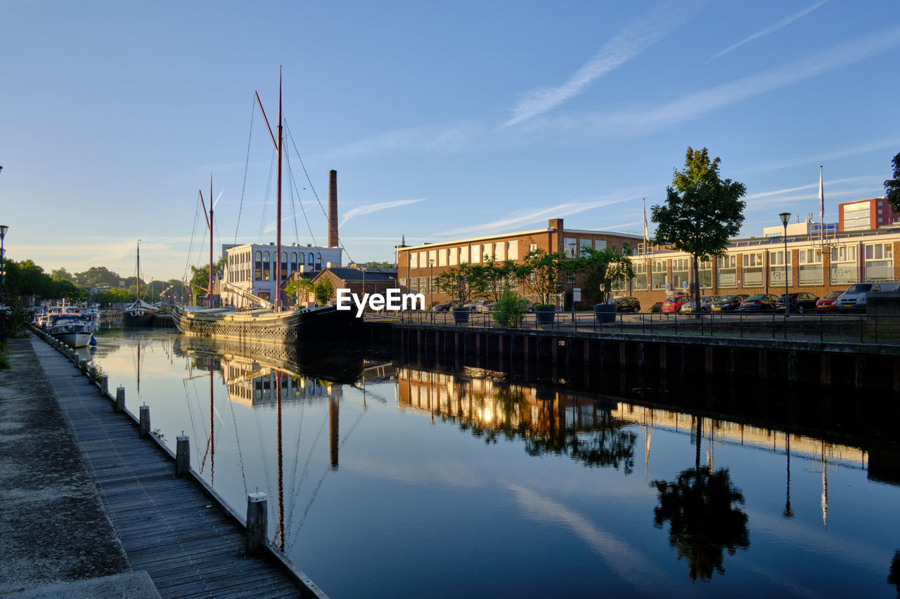 water, reflection, architecture, sky, cityscape, dock, built structure, city, waterway, river, nature, building exterior, transportation, nautical vessel, marina, harbor, travel destinations, evening, dusk, building, travel, urban area, blue, mode of transportation, waterfront, no people, outdoors, tourism, cloud, ship, vehicle, street, tree