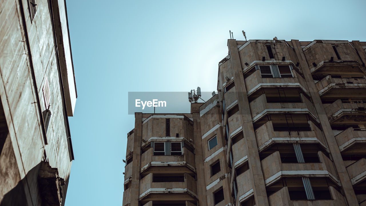 LOW ANGLE VIEW OF BUILDINGS AGAINST BLUE SKY