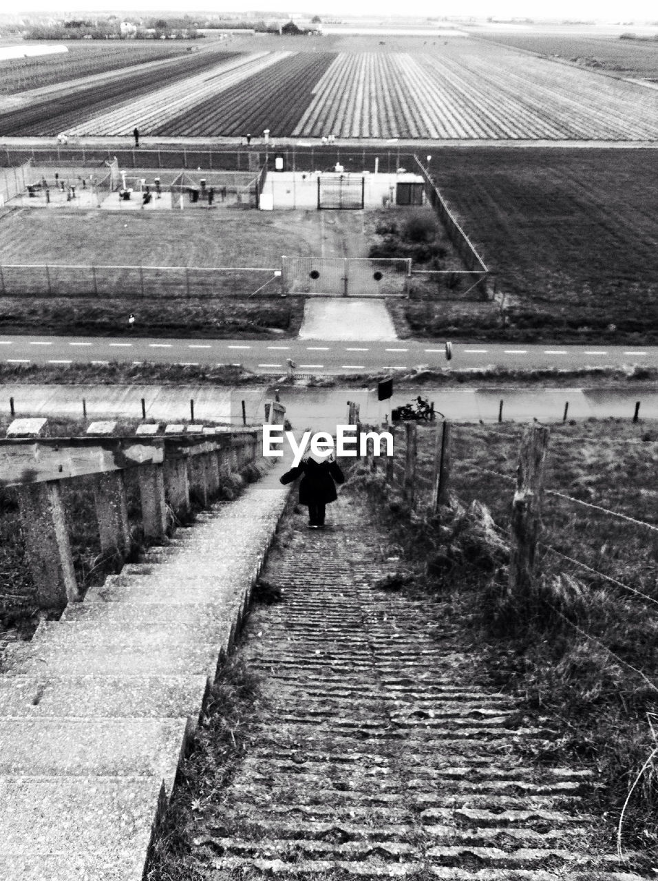 High angle view of girl moving down steps with farm in background