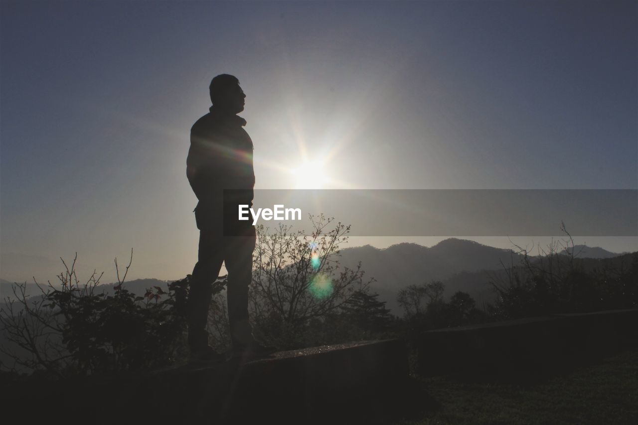 SILHOUETTE MAN STANDING ON FIELD AGAINST SKY