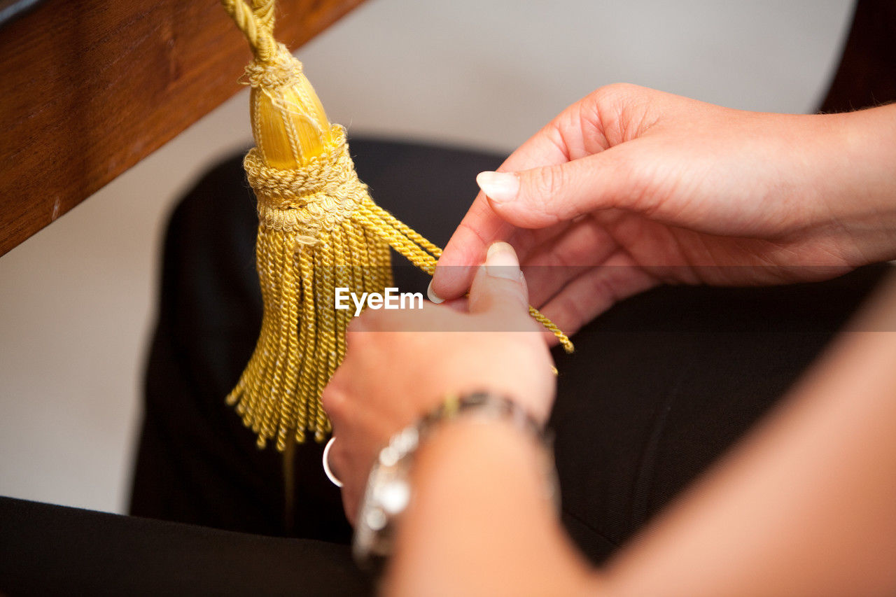 hand, yellow, adult, indoors, art, women, skill, craft, holding, one person, selective focus, jewelry, creativity, close-up, working, occupation, fashion accessory, jewellery, business