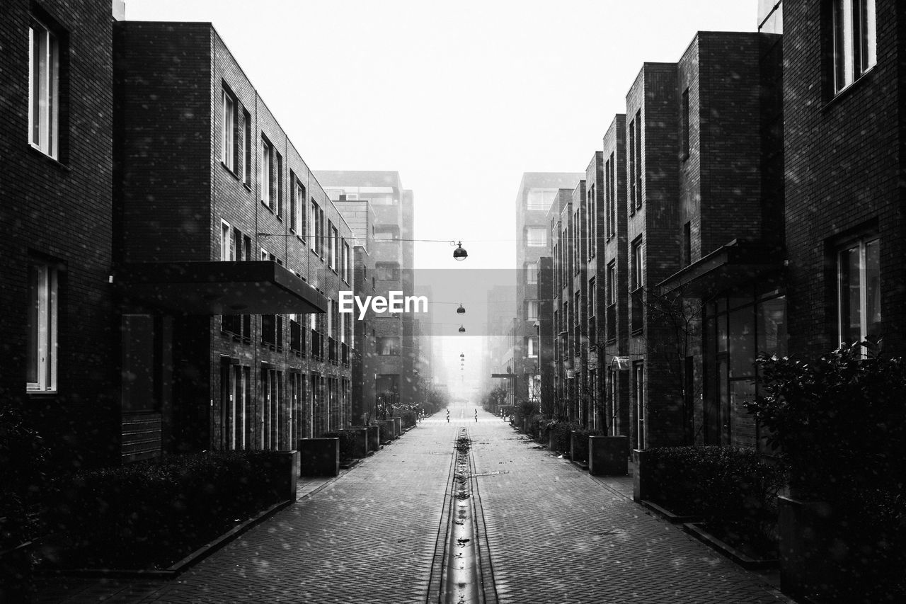 Street amidst buildings in town against sky