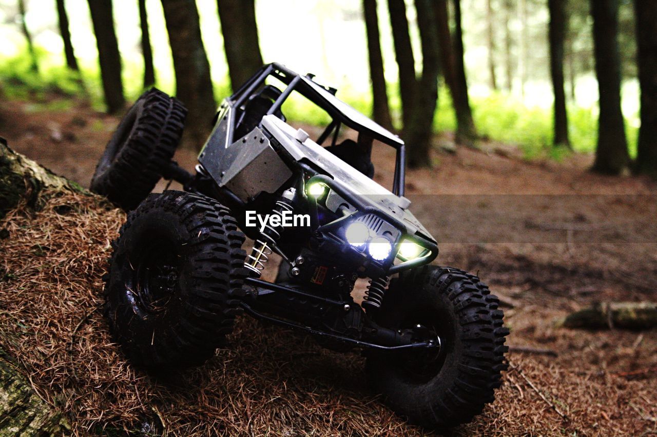 High angle close-up of toy car on grassy field in forest