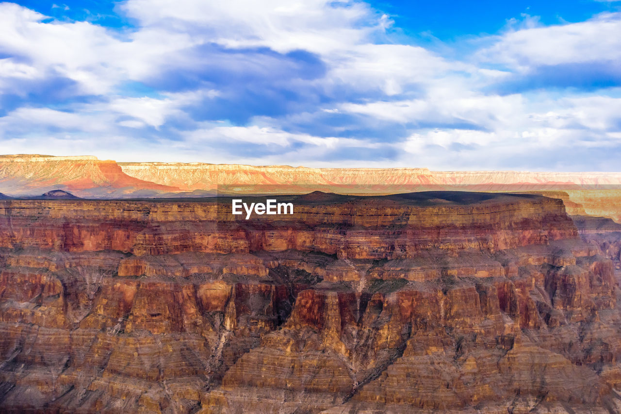 Rock formations on landscape against cloudy sky