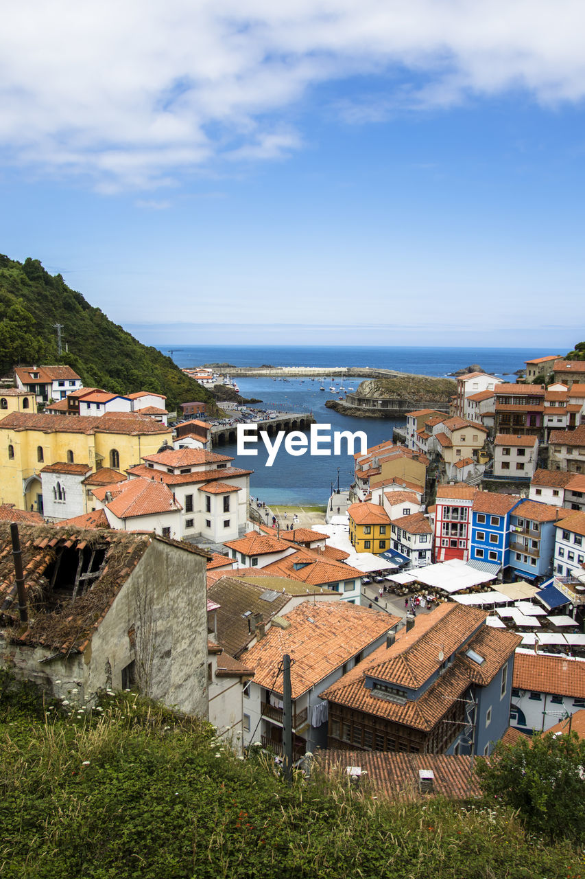 High angle view of townscape by sea against sky