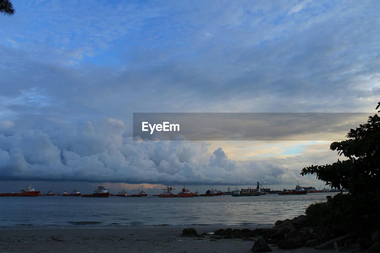 Idyllic shot of cloudy sky over commercial dock in sea
