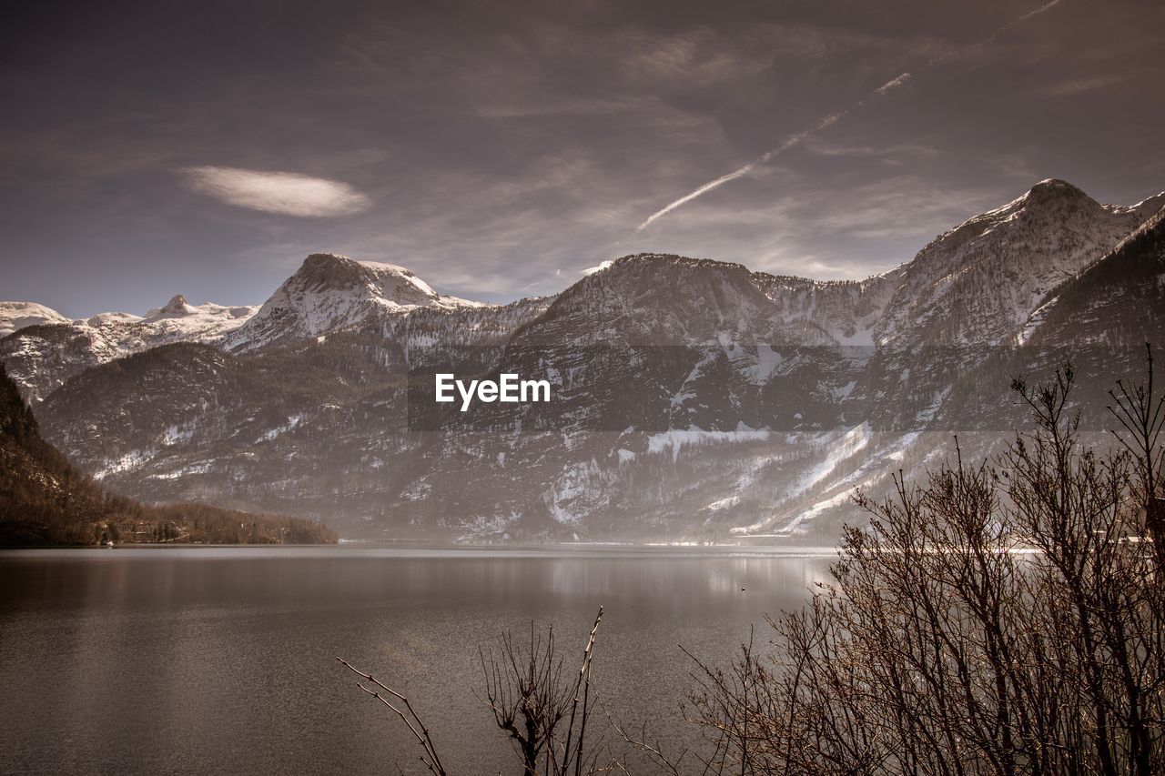 Scenic view of lake and mountains against sky during winter