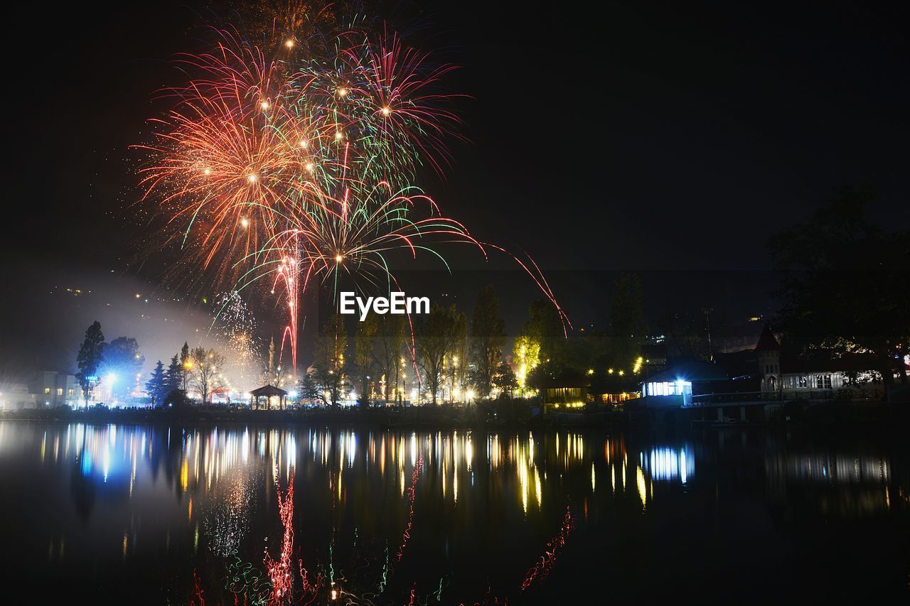 FIREWORK DISPLAY OVER LAKE AGAINST SKY