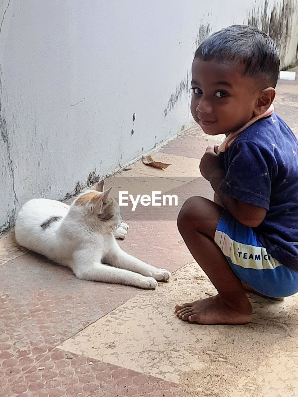 childhood, child, animal, animal themes, one person, mammal, cute, pet, one animal, domestic animals, sitting, full length, toddler, skin, men, person, portrait, casual clothing, baby, innocence, emotion, lifestyles, lap dog, nature, day, looking at camera, crouching, poverty, friendship, architecture