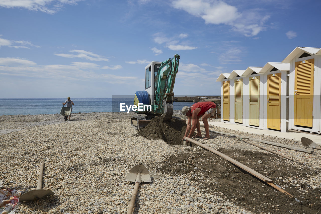 PEOPLE AT BEACH AGAINST SKY