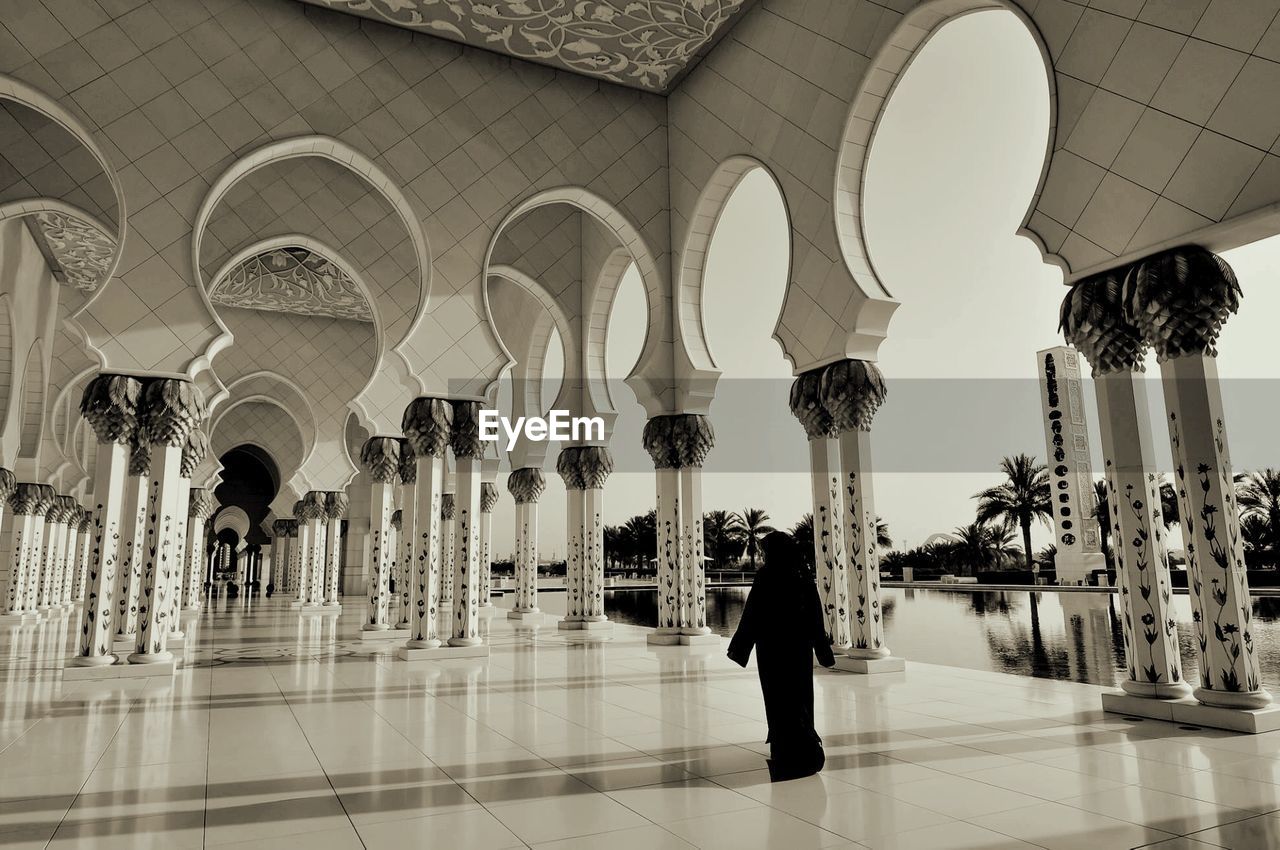 Rear view of woman in colonnade at sheikh zayed grand mosque