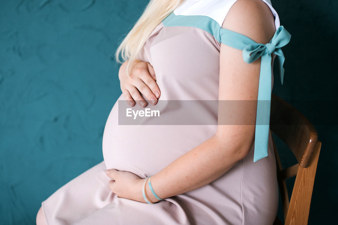 Midsection of woman sitting on seat