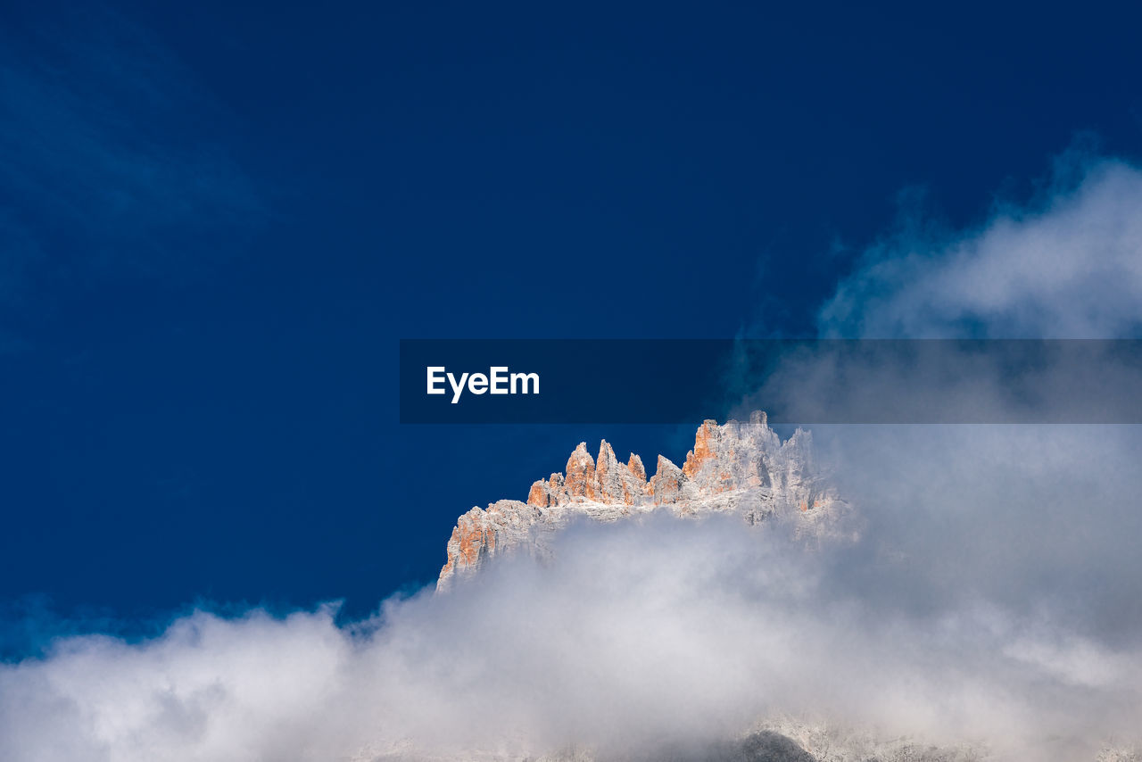 Low angle view of snowcapped mountain against sky