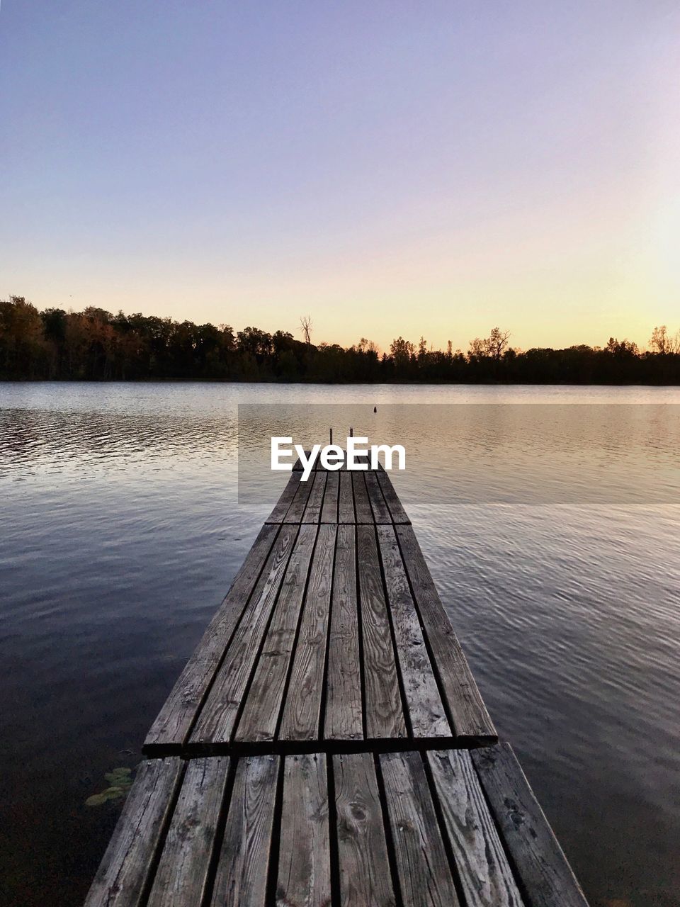 Pier over lake against clear sky