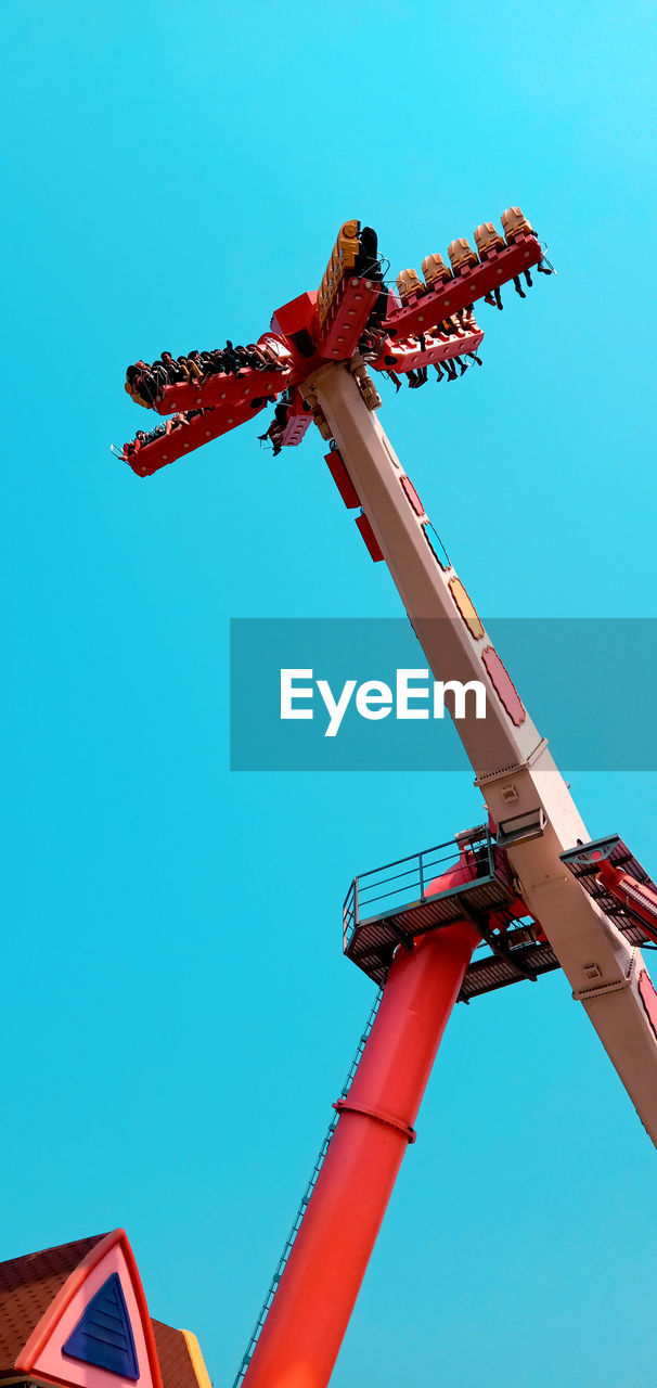 Low angle view of chain swing ride against clear blue sky