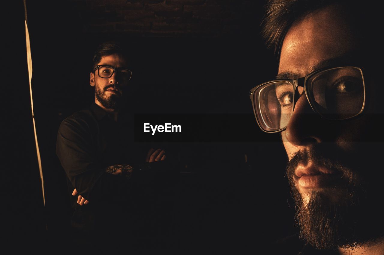 Multiple image of young man wearing eyeglasses in darkroom