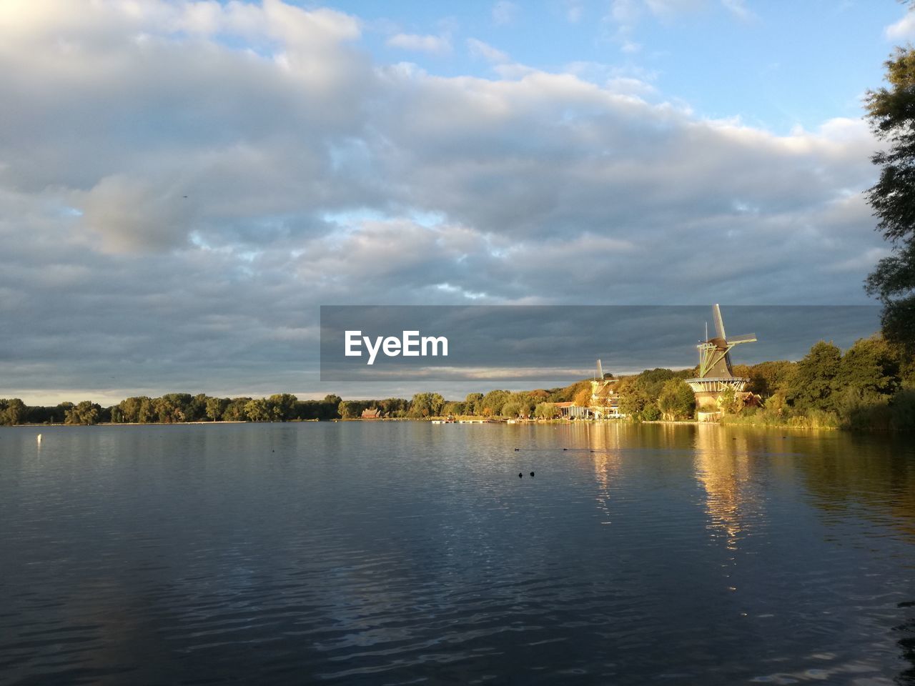 VIEW OF CALM RIVER AGAINST CLOUDY SKY