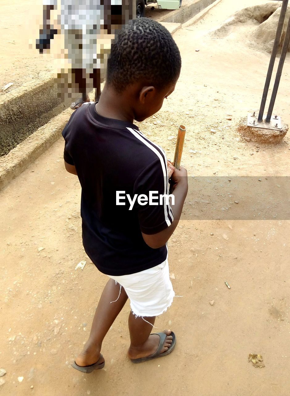 FULL LENGTH REAR VIEW OF BOY HOLDING BABY