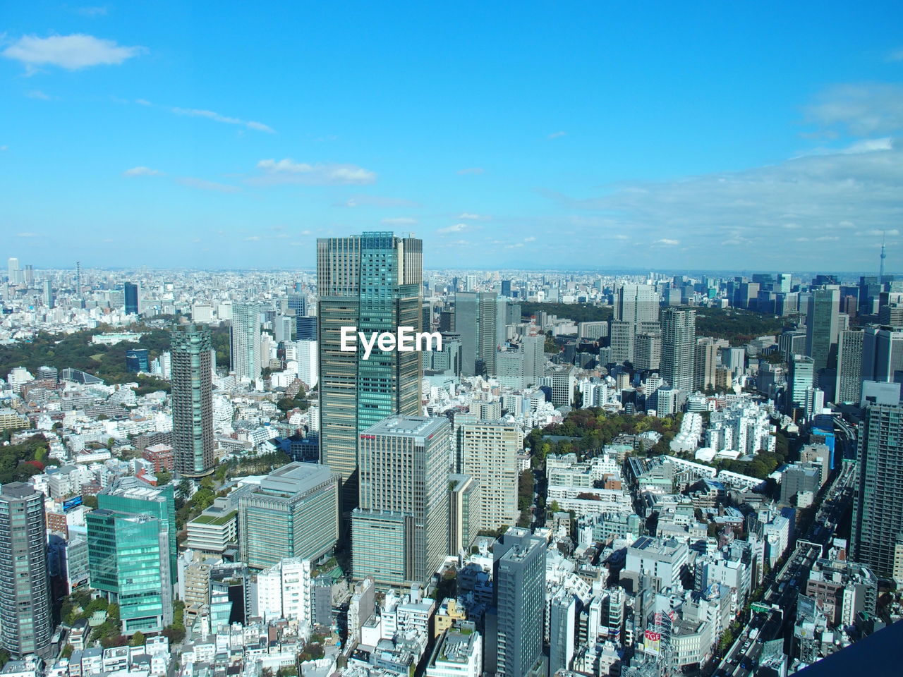 HIGH ANGLE VIEW OF MODERN CITY BUILDINGS AGAINST BLUE SKY