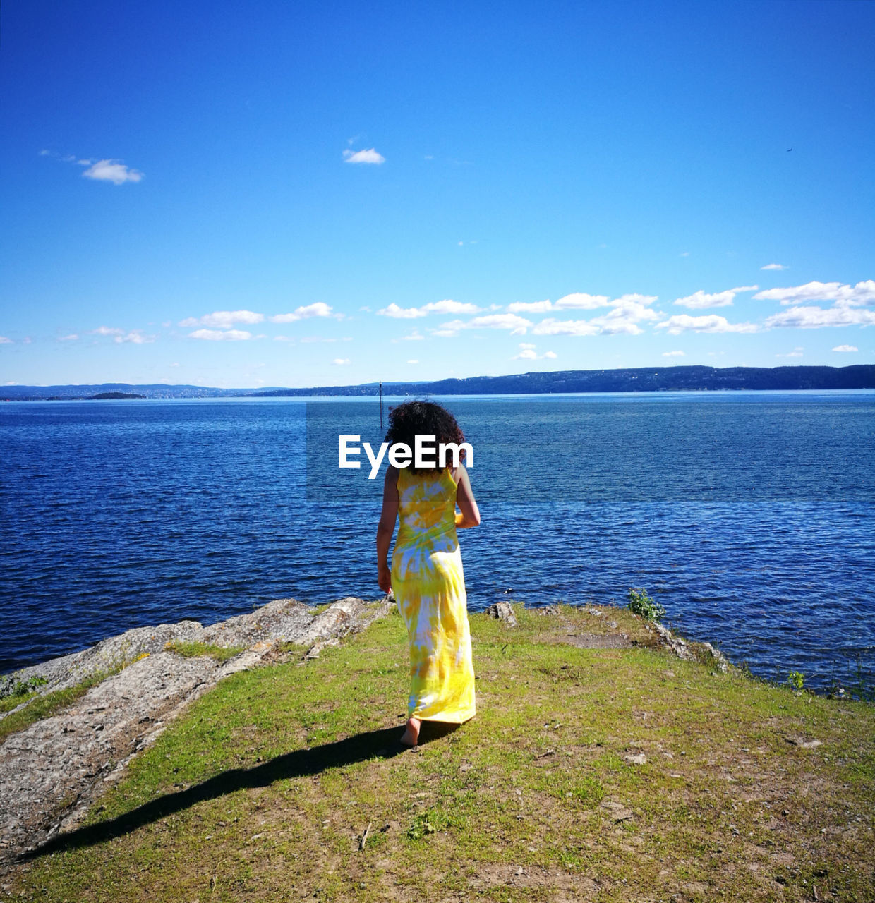 FULL LENGTH OF YOUNG WOMAN STANDING IN SEA